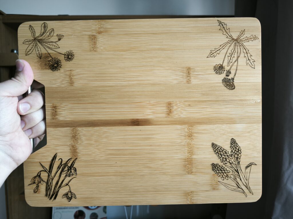 bamboo cutting board decorated with engraved images of flowers