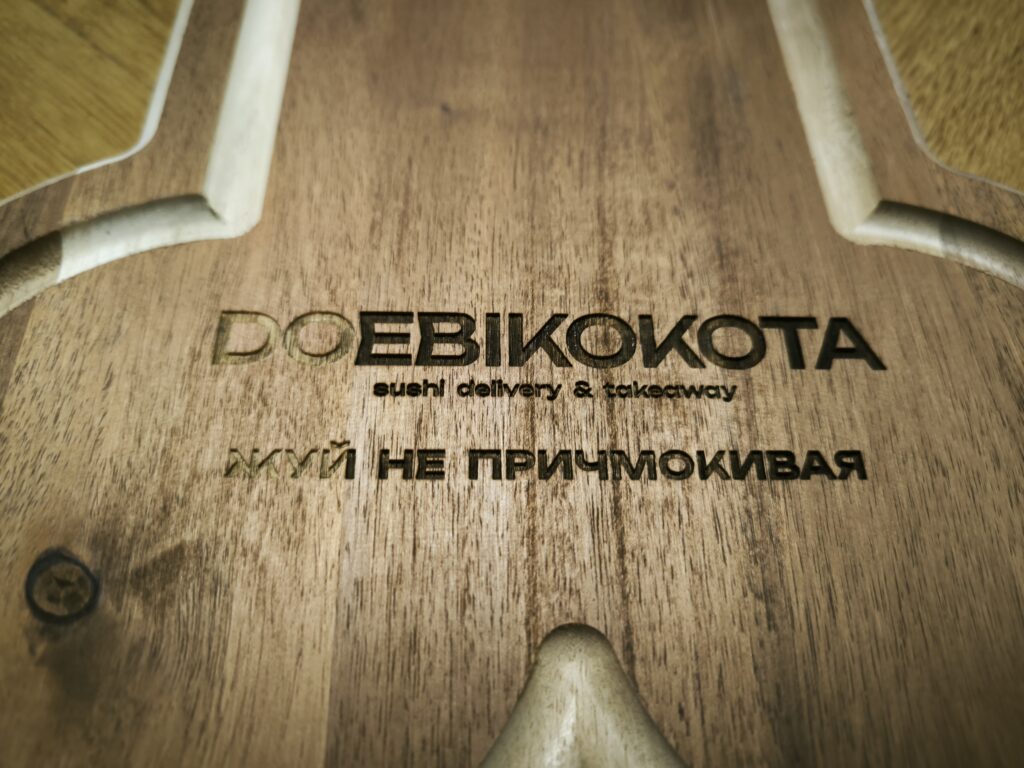 dark wooden cutting board with engraved text in ukrainian