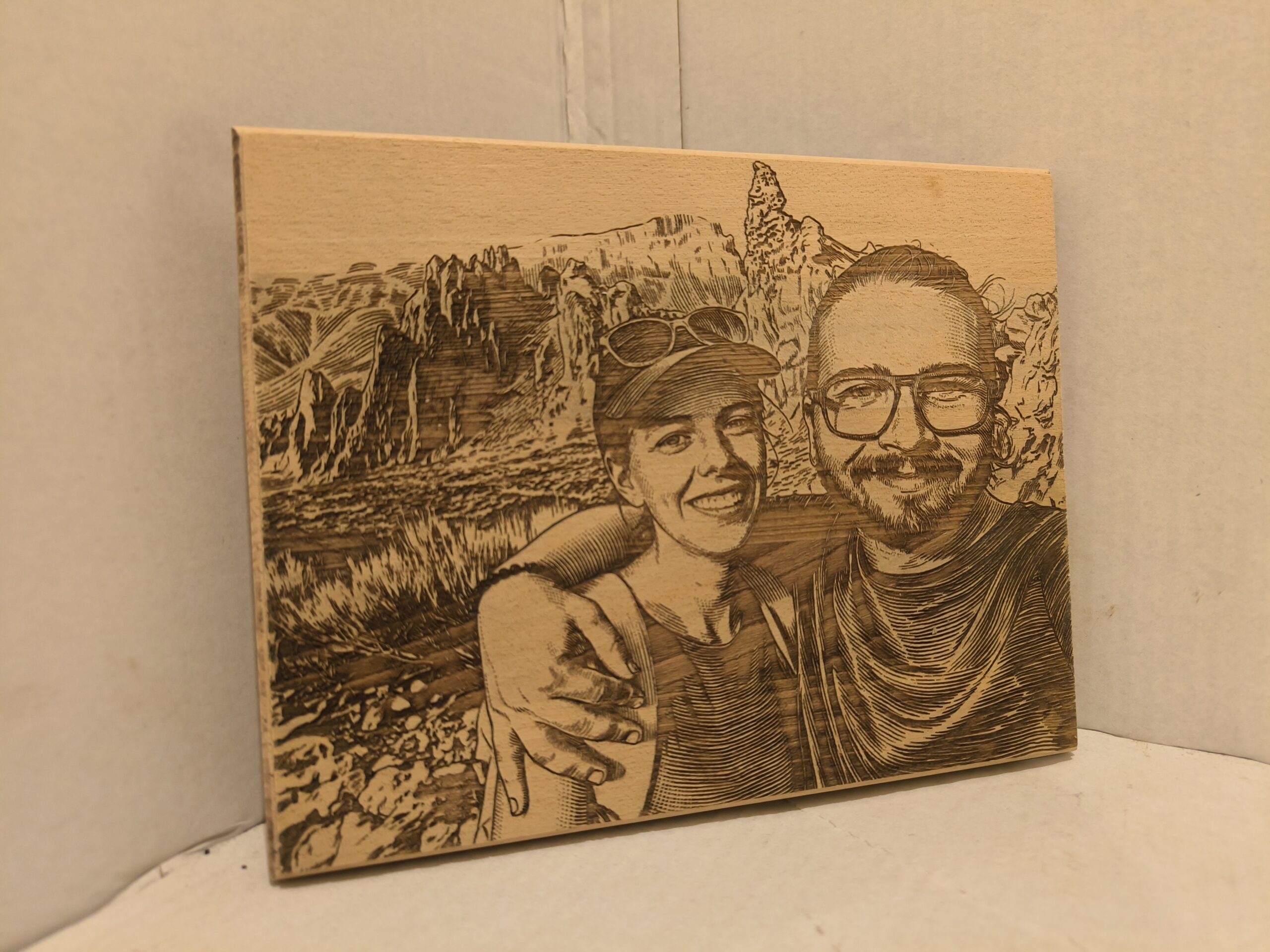 wooden picture of two people standing in mountains